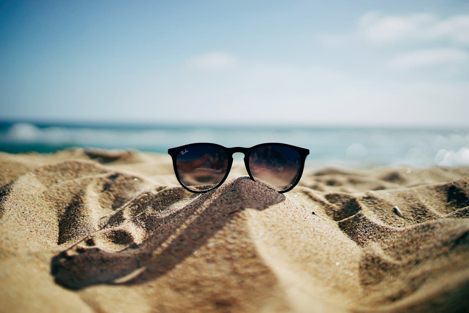 Sunglasses resting on sunlit sand